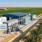 لقطة علوية تظهر أفضل محطة تحلية مياه للمزارع متكاملة بنظام الحاويات (Containerized)، مزودة بألواح طاقة شمسية وخزانات مياه عذبة لري مساحات زراعية شاسعة بكفاءة عالية.