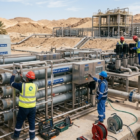 فريق عمل متكامل من المهندسين والفنيين يباشرون أعمال صيانة محطات تحلية مياه الآبار الميدانية في منطقة صحراوية لضمان كفاءة استخراج وتنقية المياه.