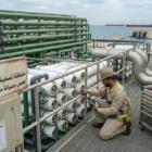 فني يتابع صيانة لوحات تحكم محطات التحلية ميدانياً.