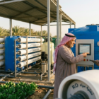 محطة تحلية مياه المزارع بالسعودية مع خزان أخضر ومزارع تقليدي.